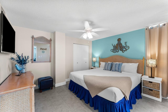 bedroom with a closet, baseboards, ceiling fan, and light tile patterned flooring