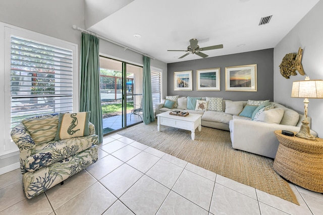 living room featuring tile patterned flooring, visible vents, and ceiling fan