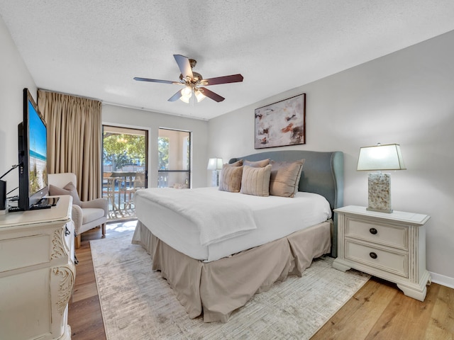 bedroom featuring light wood finished floors, access to exterior, baseboards, ceiling fan, and a textured ceiling