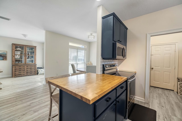 kitchen with light wood-type flooring, visible vents, appliances with stainless steel finishes, and butcher block counters