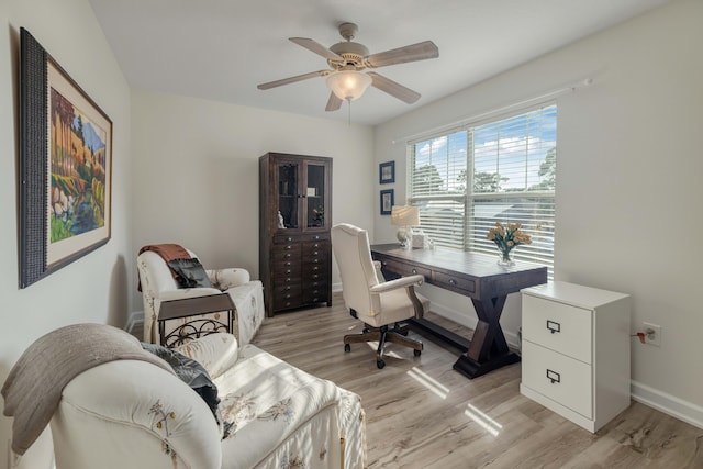 office space featuring a ceiling fan, baseboards, and light wood finished floors