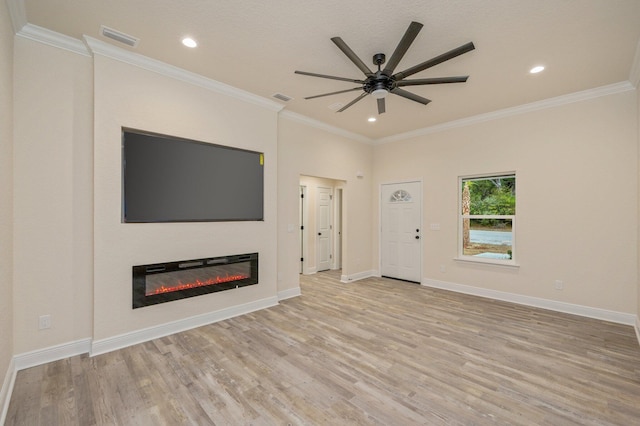 unfurnished living room with light wood-type flooring, visible vents, and a glass covered fireplace