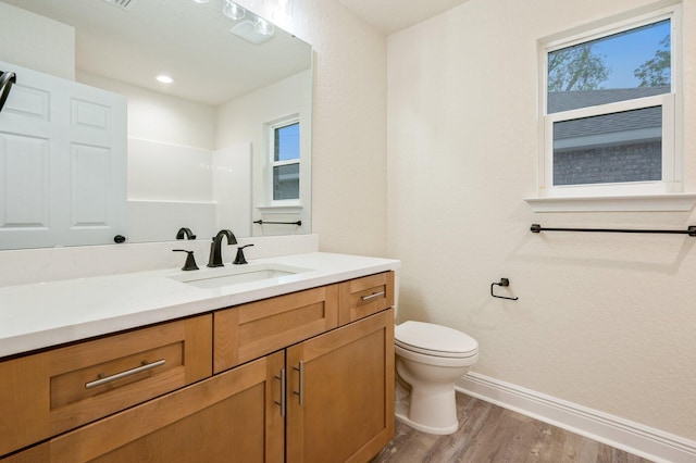 full bathroom with toilet, vanity, baseboards, and wood finished floors