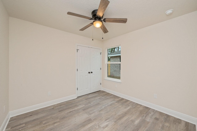 unfurnished room featuring light wood-type flooring, baseboards, and ceiling fan