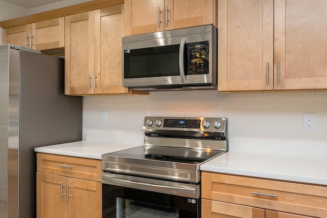 kitchen featuring light countertops, light brown cabinets, and appliances with stainless steel finishes