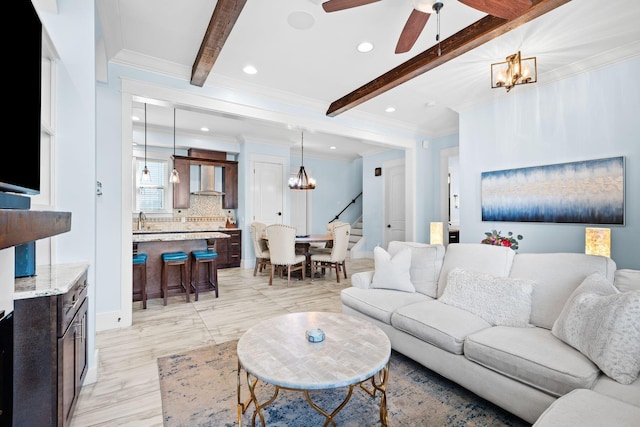 living room with beam ceiling, recessed lighting, stairs, crown molding, and ceiling fan with notable chandelier