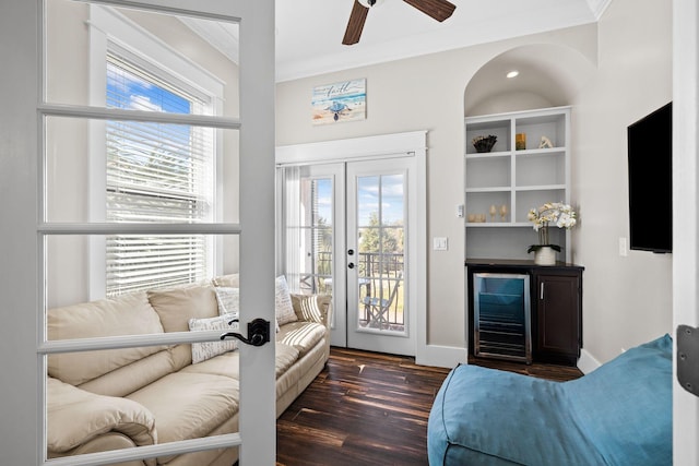 living area with crown molding, ceiling fan, wine cooler, a dry bar, and wood finished floors