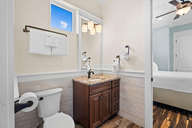 bathroom featuring a wainscoted wall, vanity, wood finished floors, and a ceiling fan