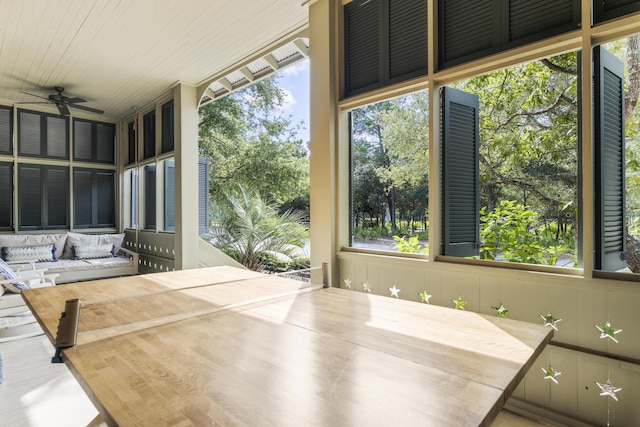 unfurnished sunroom with wood ceiling, a healthy amount of sunlight, and ceiling fan