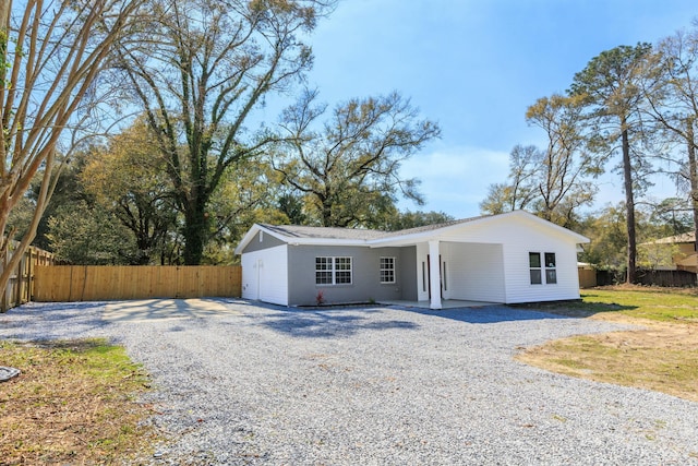 view of front facade with driveway and fence