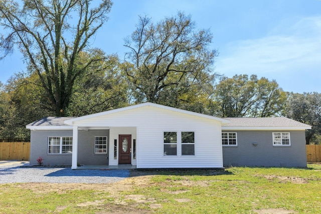 ranch-style home with brick siding, covered porch, a front lawn, and fence