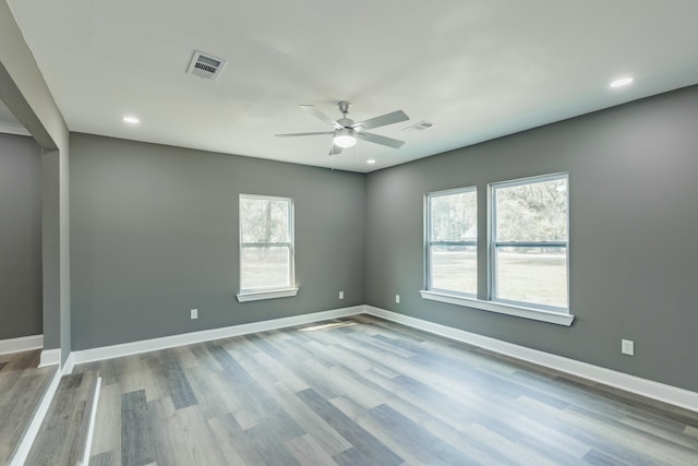 empty room with visible vents, baseboards, and wood finished floors