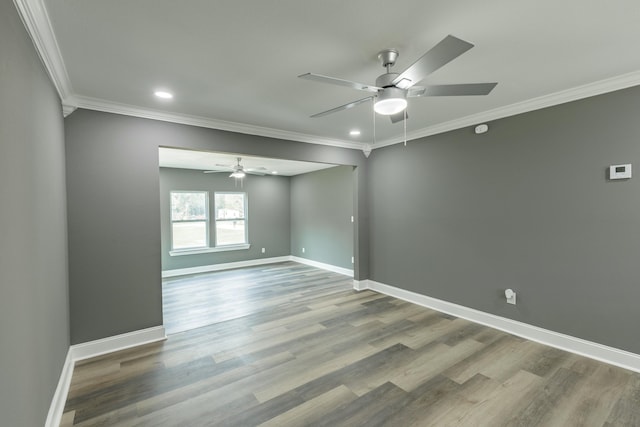 empty room featuring ornamental molding, baseboards, and wood finished floors