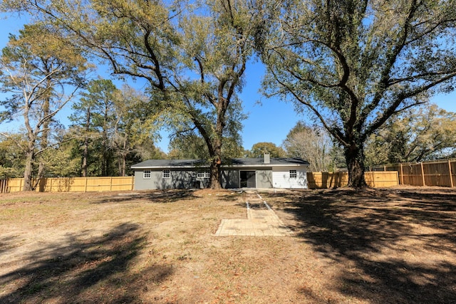 rear view of property featuring a fenced backyard