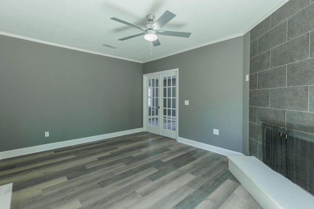 spare room featuring wood finished floors, baseboards, visible vents, ornamental molding, and french doors