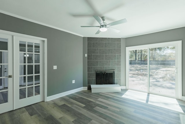 unfurnished living room with a fireplace, crown molding, french doors, and wood finished floors