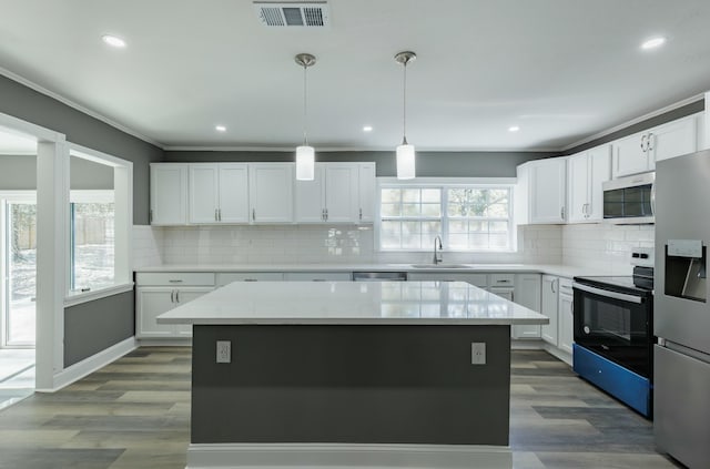 kitchen featuring a sink, visible vents, dark wood-style flooring, and stainless steel appliances