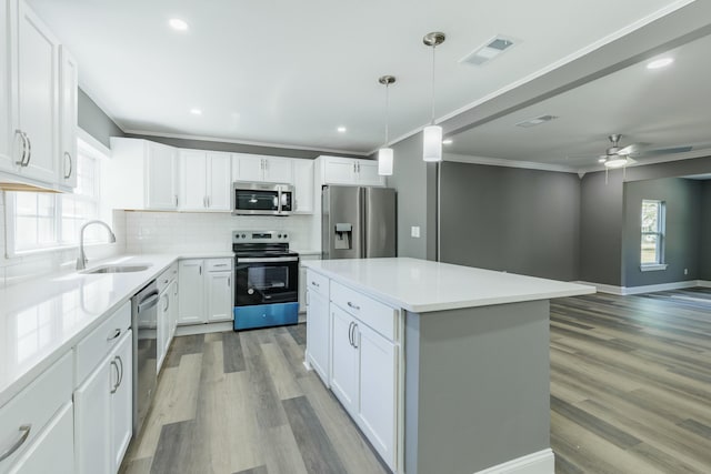 kitchen featuring tasteful backsplash, visible vents, crown molding, light wood-style floors, and stainless steel appliances