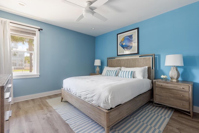 bedroom featuring ceiling fan, baseboards, and wood finished floors