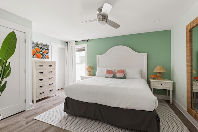 bedroom with baseboards, wood finished floors, and a ceiling fan