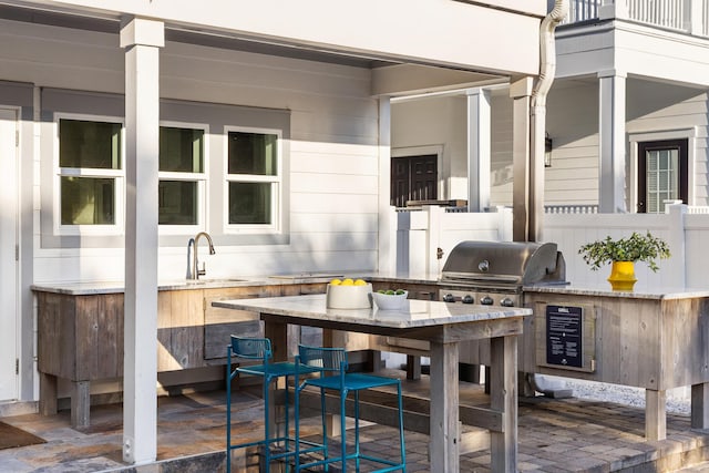 view of patio featuring area for grilling, a sink, grilling area, wine cooler, and outdoor dining area