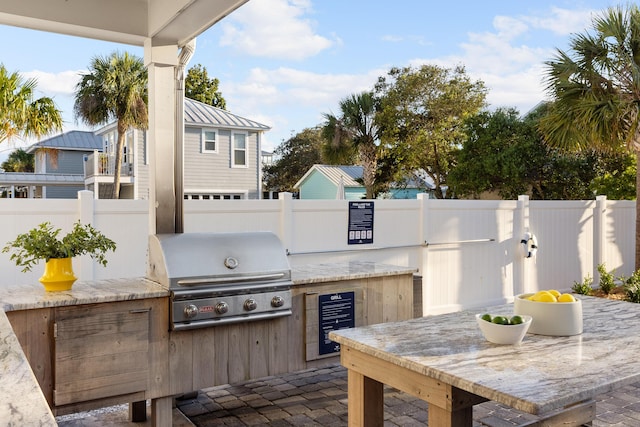 view of patio / terrace with an outdoor kitchen, a fenced backyard, and a grill