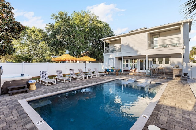 view of swimming pool featuring a fenced in pool, a patio, fence, and a hot tub