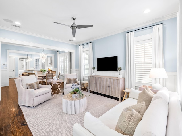 living area featuring crown molding, wood finished floors, visible vents, and wainscoting