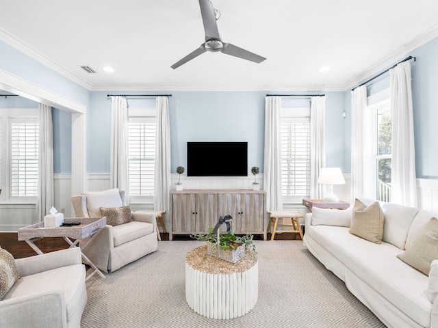 living room with visible vents, a ceiling fan, recessed lighting, wainscoting, and crown molding