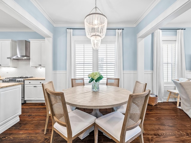 dining space with a notable chandelier, wainscoting, crown molding, and dark wood-style flooring