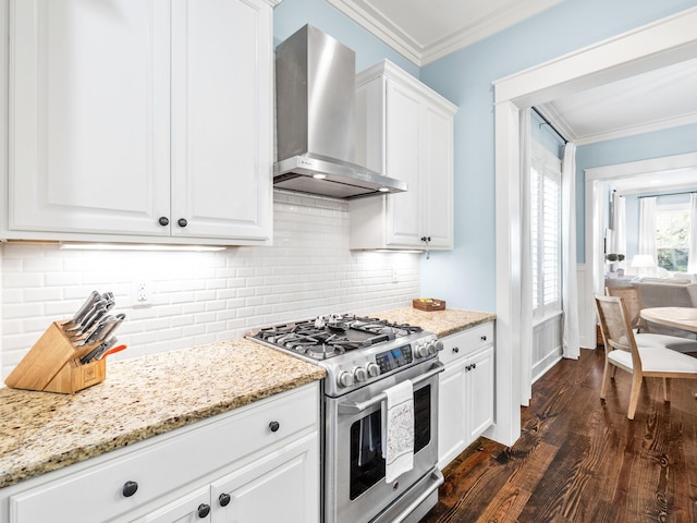 kitchen featuring dark wood-type flooring, light stone counters, stainless steel range with gas cooktop, wall chimney exhaust hood, and crown molding