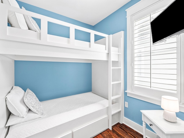 bedroom with baseboards and dark wood finished floors