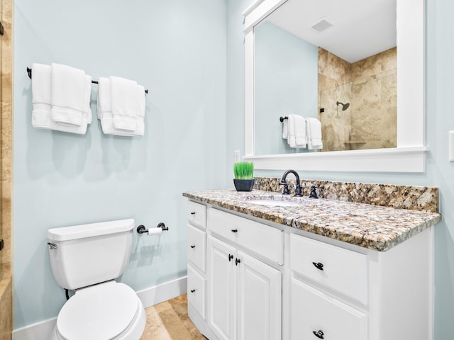 full bathroom with vanity, visible vents, baseboards, tiled shower, and toilet