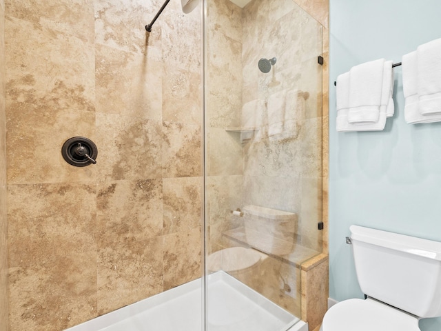 full bath featuring toilet and a tile shower