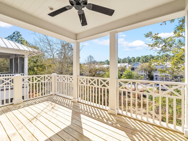 wooden terrace featuring a ceiling fan and a sunroom