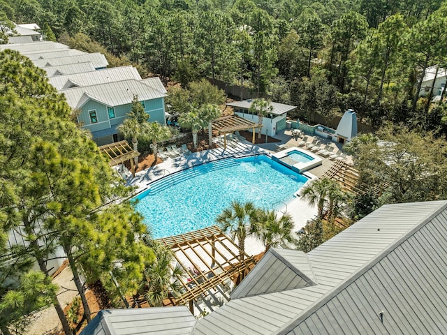 pool with a patio area and a community hot tub