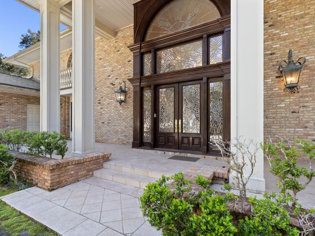 entrance to property featuring brick siding and a porch