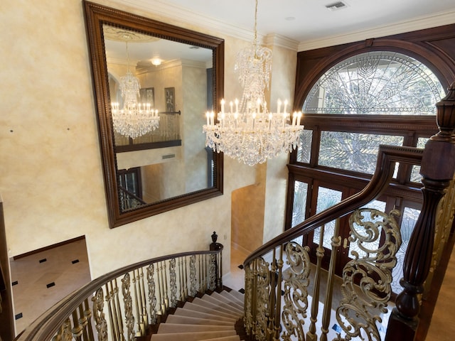 stairway with a chandelier, visible vents, crown molding, and a high ceiling