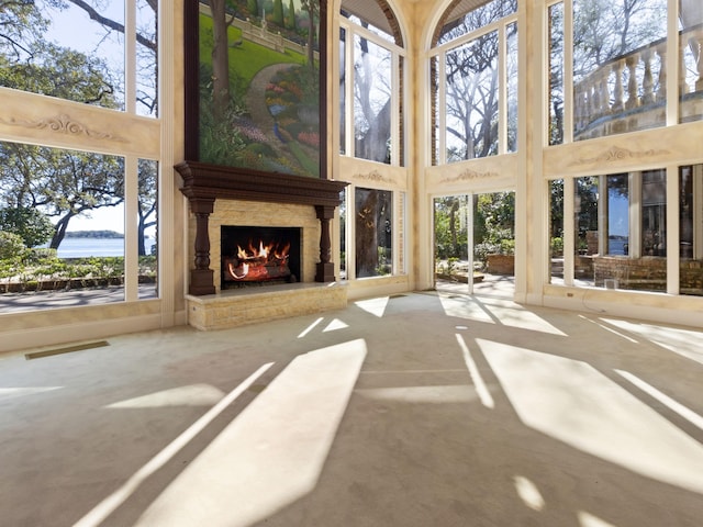 unfurnished sunroom featuring visible vents and a large fireplace