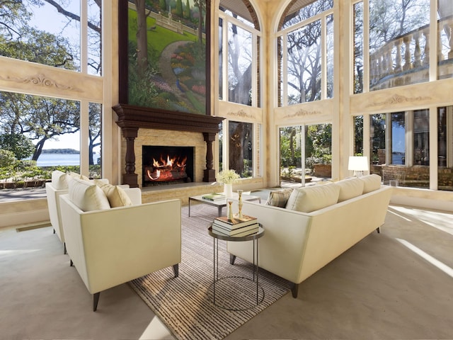 living area with a high ceiling, a wealth of natural light, and a large fireplace