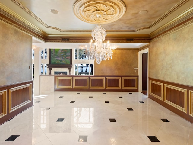 unfurnished dining area featuring a decorative wall, crown molding, and a wainscoted wall