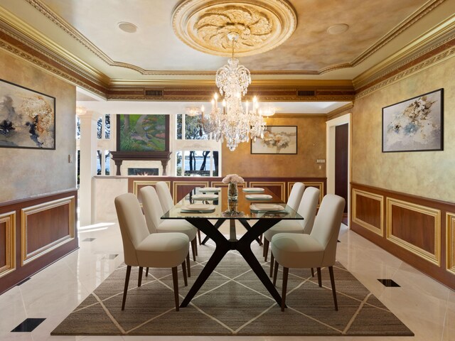 dining space featuring a wainscoted wall, a decorative wall, and ornamental molding