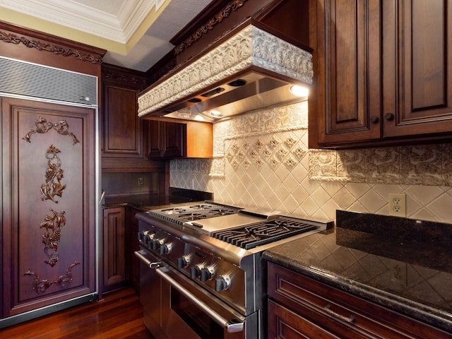 kitchen with range with two ovens, dark wood-type flooring, custom range hood, crown molding, and backsplash