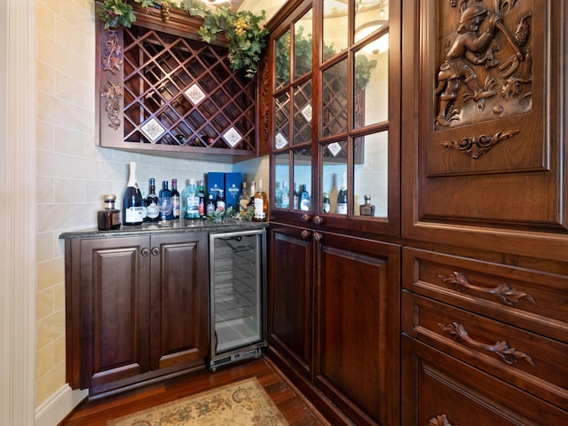 bar with beverage cooler, dark wood-style floors, and a dry bar