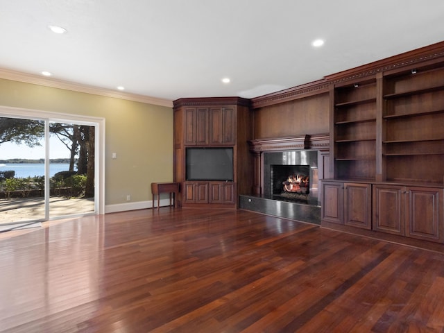 unfurnished living room featuring a high end fireplace, crown molding, baseboards, a water view, and dark wood-style floors