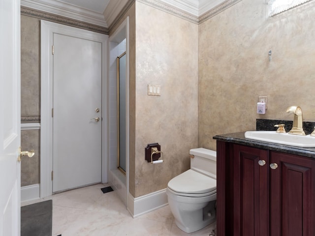 bathroom with vanity, toilet, baseboards, and a shower with shower door