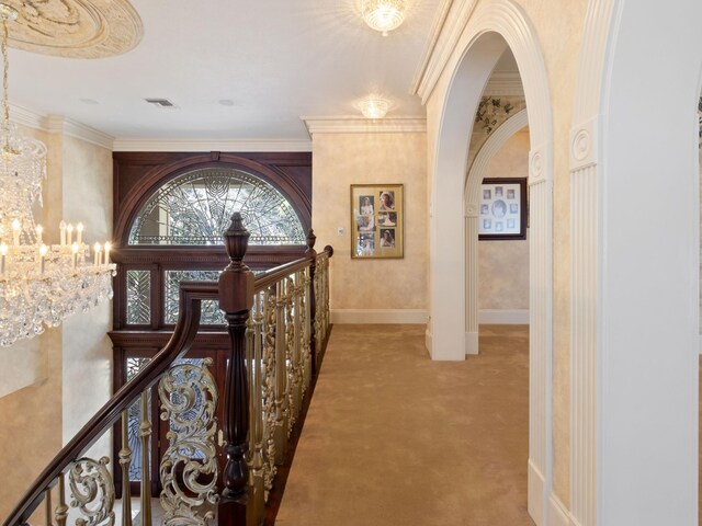 hallway with visible vents, light carpet, an upstairs landing, arched walkways, and an inviting chandelier