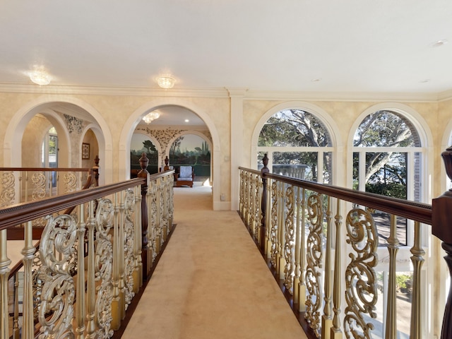 hall with ornamental molding and light carpet