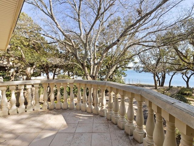 view of patio with a balcony and a water view