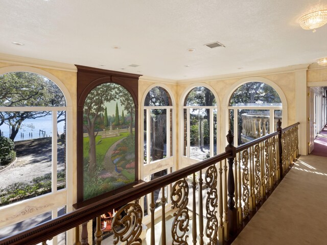 interior space with carpet flooring, crown molding, and plenty of natural light